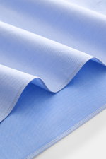 Makroaufnahme des hellblauen Borrelli Business Hemd 'Nando' Haifisch-Kragen aus Gabardine, weich, Regular Fit, Perlmuttknöpfe, Sportmanschette, gerundeter Saum.