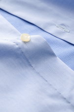 Borrelli Business Hemd 'Nando' Haifisch-Kragen hellblau, Detailaufnahme von Knopf und Stoff, Gabardine aus reiner Baumwolle, Regular Fit, weiche fein strukturierte Qualität, französische Knopfleiste mit Perlmuttknöpfen, klassische Sportmanschette, gerunde