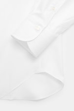 Close-up from above of the Finamore Business Shirt 'Sergio Napoli' Spread Collar white sleeve and cuff in pure Giza cotton, smooth touch, regular fit, extra-long sleeves, spread collar, French placket, classic sport cuff, rounded hemline.