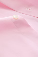 Finamore Business-Hemd 'Sergio Napoli' Haifisch-Kragen rosé, Nahaufnahme der Knopfleiste und glatten Twill-Oberfläche aus ägyptischer Giza-Baumwolle, fotografiert aus schräger Perspektive.