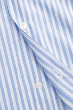 Nahaufnahme des Finamore Business-Hemd 'Sergio Napoli' Haifisch-Kragen hellblau/weiß gestreift aus glatter Giza-Baumwolle, Popeline, Slim Fit, mit Knopf und Knopfloch, fotografiert aus seitlicher Perspektive.
