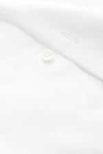 Nahaufnahme des weißen Fray Business Hemd Haifisch-Kragen 'Nello' aus reiner Baumwolle Gabardine mit Knopfloch und weichem Griff, Slim Fit, Sportmanschette, leicht gerundetem Saum, fotografiert aus schräger Perspektive.