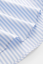Close-up view of the slightly rounded hemline and fabric texture of the Fray Shirt shark collar 'Nello' light blue/white striped, made from pure cotton with a slim fit, slight texture, shark collar, and classic sport cuff, perfect for warm office days.