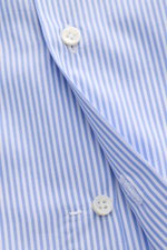Nahaufnahme aus schräger Perspektive des Borrelli Business Hemd 'Nando' Haifisch-Kragen blau/weiß gestreift mit Popeline aus reiner Baumwolle, leichtem, glattem Griff, klassischem Streifenmuster, Slim Fit, französischer Knopfleiste mit Perlmuttknöpfen, kl