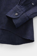 Close-up front view of the navy von Braun Leinenhemd Haifisch-Kragen showcasing the cuff, button, and linen texture with rounded hem. <p><span class="_fadeIn_m1hgl_8">Mühelose </span><span class="_fadeIn_m1hgl_8">Leichtigkeit</span><span class="_fadeIn_m1