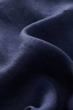 Close-up image of navy linen fabric showing texture and weave, photographed from a macro perspective, highlighting the material of the von Braun Leinenhemd Haifisch-Kragen navy. <p><span class="_fadeIn_m1hgl_8">Mühelose </span><span class="_fadeIn_m1hgl_8