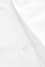 BRAUN Hamburg Smokinghemd Kläppchen-Kragen weiß, Nahaufnahme seitlich, Popeline Baumwolle, glatter Griff, Extra Slim Fit, verdeckte Knopfleiste mit Perlmuttknöpfen, elegante Umschlagmanschette, gerundeter Saumverlauf.
