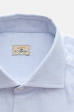 Nahaufnahme aus schräger Perspektive des Sonrisa Flanellhemd Haifisch-Kragen hellblau meliert mit weichem Baumwollstoff, französischer Knopfleiste und kleinem Weblabel.
