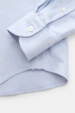 Nahaufnahme vom Saum und klassischer Sportmanschette des Sonrisa Flanellhemds Haifisch-Kragen hellblau meliert aus reiner Baumwolle, Slim Fit, weicher Griff, mit französischer Knopfleiste und kleinem Weblabel.