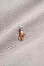 Nahaufnahme des Polo Ralph Lauren Oxford-Hemd Button-Down-Kragen grau mit mehrfarbigem Polospieler-Stitching auf fein strukturiertem Baumwollstoff.