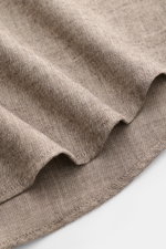 Nahaufnahme des gerundeten Saumverlaufs vom BRAUN Hamburg Flanellhemd Haifisch-Kragen taupe mit feinem Fischgrat aus Baumwolle, sehr weichem Griff, Slim Fit, französischer Knopfleiste und klassischer Sportmanschette, aus schräger Perspektive.