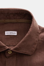 Close-up front view of the brown von Braun Linen shirt shark collar brown showing collar, top button, and fabric texture, pure linen.  
<p><span class="_fadeIn_m1hgl_8">Effortlessly </span><span class="_fadeIn_m1hgl_8">lightweight</span><span class="_fade