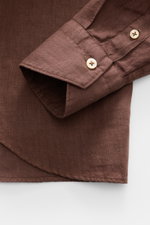 Close-up view of von Braun Linen shirt shark collar brown sleeve cuff and rounded hem in pure linen with soft, airy fabric texture.

<p><span class="_fadeIn_m1hgl_8">Effortlessly </span><span class="_fadeIn_m1hgl_8">lightweight</span><span class="_fadeIn_