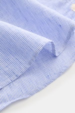 Close-up angled view of von Braun Linen shirt shark collar blue/white striped fabric showing fine stripes, airy pure linen texture, and rounded hem. Effortlessly lightweight: This VON BRAUN shirt in pure linen has an airy feel and a relaxed look – a styli