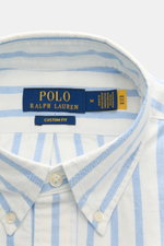 Nahaufnahme des Polo Ralph Lauren Casual Hemd Button-Down-Kragen blau/weiß gestreift, Slim Fit, weiche reine Baumwolle, leichte Qualität, mit Logo-Stickerei, Rückenpasse und gerundetem Saum, von oben fotografiert.