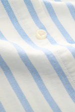 Nahaufnahme des Polo Ralph Lauren Casual Hemd Button-Down-Kragen blau/weiß gestreift mit feiner Baumwoll-Leinwandbindung, weichem Griff und Knopf, fotografiert aus schräger Perspektive.