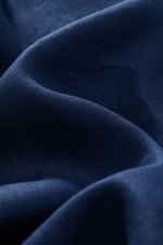 Das Bild zeigt eine Nahaufnahme der typischen Materialstruktur des Polo Ralph Lauren Leinenhemd Button-Down-Kragen türkis aus reinem, leichtem Leinen, fotografiert aus nächster Nähe.