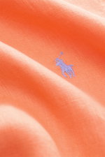 Nahaufnahme eines orangefarbenen Polo Ralph Lauren Leinenhemd Button-Down-Kragen mit feiner Leinenstruktur und blauem Polo-Stitching, Detailansicht.
