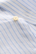 Close-up front view of Polo Ralph Lauren Linen shirt button-down collar white/light blue striped, showing button and fabric texture.

<p>A summer classic from POLO RALPH LAUREN: This minimalist slim fit shirt in the finest linen with button-down collar an