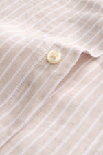Nahaufnahme des Polo Ralph Lauren Leinenhemd Button-Down-Kragen beige/weiß gestreift mit feiner Leinwandbindung und Knopf, fotografiert aus schräger Perspektive.