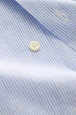 Nahaufnahme aus schräger Perspektive des Polo Ralph Lauren Oxford-Hemds Haifisch-Kragen hellblau/weiß gestreift mit Knopf, weichem Leinen-Baumwollstoff und feinem Streifenmuster.