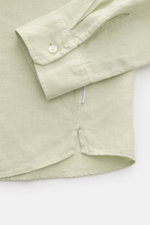 Close-up side view of 04651/ A trip in a bag Linen shirt 'Linen Guru' grandad collar pastel green showing cuff, small welt pocket, and side seam label, made of pure linen with a soft feel and regular fit, featuring a grandad collar, French button placket,