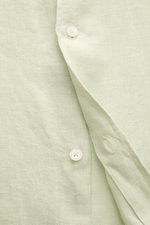 Close-up front view of 04651/ A trip in a bag Linen shirt 'Linen Guru' grandad collar pastel green showing linen texture and buttons.

Description: <p>Summer for your skin: The airy casual shirt 'Linen Guru' by 04651/ A TRIP IN A BAG is made of pure linen