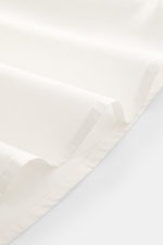 04651/ A trip in a bag Casual Hemd 'Cloudy Shirt' schmaler Kragen offwhite, Detailaufnahme der leichten, reinen Baumwolle aus seitlicher Perspektive.