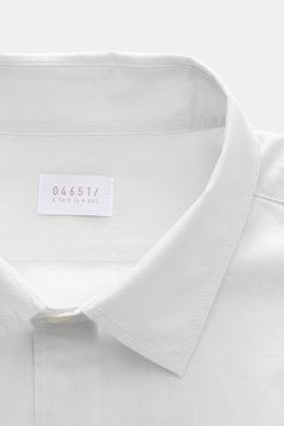 Close-up front view of the collar and label of the 04651/ A trip in a bag Casual shirt 'Cloudy Shirt' slim collar light grey.

<p><span class="_fadeIn_m1hgl_8">Lightweight and comfortable for hot days: The casual shirt 'Cloudy Shirt' by 04651/ A TRIP IN A
