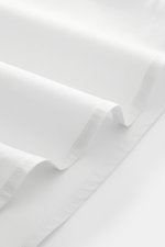 Close-up view of the light grey fabric folds of the 04651/ A trip in a bag Casual shirt 'Cloudy Shirt' slim collar light grey, showing fine stitching and smooth texture.

<p><span class="_fadeIn_m1hgl_8">Lightweight and comfortable for hot days: The casua