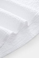 Close-up fabric detail of the 04651/ A trip in a bag Seersucker shirt Kent collar white, showing textured pure cotton seersucker from a top-down perspective.

<p><span class="_fadeIn_m1hgl_8">Effortlessly </span><span class="_fadeIn_m1hgl_8">casual</span>