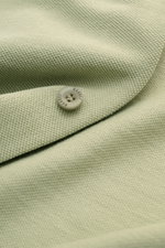 Nahaufnahme des 04651/ A trip in a bag Piqué-Hemd schmaler Kragen salbei mit feiner Piqué-Struktur und Knopf, Sicht auf Baumwollstoff.