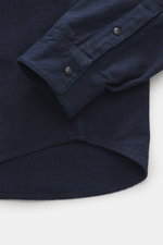Stone Island Casual Shirt 'Indigo Denim' navy shown from a close-up side angle, highlighting the cotton twill fabric, soft touch, regular fit, covered snap button placket, Kent collar, classic sports cuff, patch chest pocket with flap, and tonal logo stit