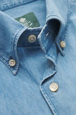 Nahaufnahme aus schräger Perspektive des Borrelli Jeanshemd Button-Down-Kragen rauchblau aus weichem, leichtem Denim, handgefertigt, Slim Fit, mit französischer Knopfleiste, klassischer Sportmanschette und gerundetem Saum.