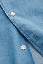 Nahaufnahme des Borrelli Jeanshemd Button-Down-Kragen blau aus reiner Baumwolle, weiche, leichte Qualität, handgefertigt, Slim Fit, französische Knopfleiste, Sportmanschette, gerundeter Saum, seitlich fotografiert.