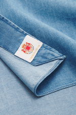 Borrelli Jeanshemd Button-Down-Kragen blau in Nahaufnahme von oben, Denim aus reiner Baumwolle, weiche, leichte Qualität, handgefertigt, Slim Fit, französische Knopfleiste, klassische Sportmanschette, gerundeter Saumverlauf.