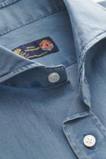 Nahaufnahme aus schräger Perspektive des Borrelli Jeanshemds Haifisch-Kragen rauchblau mit Denim aus reiner Baumwolle, weicher, leichter Qualität, handgefertigt, Slim Fit, Haifisch-Kragen, aufgesetzter Knopfleiste, klassischer Sportmanschette und gerundet