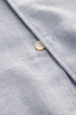 Nahaufnahme des Borrelli Casual Hemd 'Ettore' Haifisch-Kragen rauchblau meliert, von schräg oben. Mix aus Baumwolle und Schurwolle, weicher Griff, Slim Fit, von Hand genäht, Haifisch-Kragen, französische Knopfleiste mit Perlmuttknöpfen, klassische Sportma