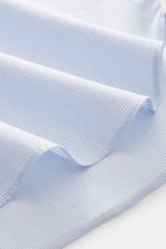 Close-up of the Finamore Casual Shirt 'Edoardo Napoli' Shark Collar Light Blue/White Striped fabric, showing fine diagonal stripes and smooth texture, photographed from a top-down perspective. The model 'Edoardo Napoli' by the traditional house FINAMORE i
