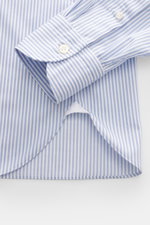 Close-up from above of the cuff and hem of the Giampaolo Casual shirt shark collar light blue/white striped, made of pure cotton with soft feel, classic stripe pattern, regular fit, shark collar, French placket, classic sport cuff, and rounded hem. A real