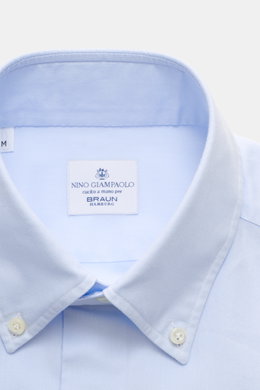 Close-up frontal view of the light blue Giampaolo Oxford-Hemd Button-Down-Kragen showing the fine Oxford cotton fabric, button-down collar, and label, a classic slim fit office shirt with French placket, sport cuffs, back waist darts, and rounded hem.