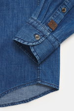 Nahaufnahme des Ärmels und Saumverlaufs des Jacob Cohen Jeanshemd schmaler Kragen blau aus reiner Baumwolle, Slim Fit, weicher Griff, Kent-Kragen, Knopfleiste, dezentes Logo-Stitching, Sportmanschette, leicht gerundeter Saum, fotografiert von oben.