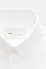 Ami Paris Oxford Shirt Button-Down Collar White shown from the front close-up, classic modern design, pure cotton, slightly textured feel, regular fit, button placket, classic sport cuff, typical logo stitching, slightly rounded hemline. Classic modern in