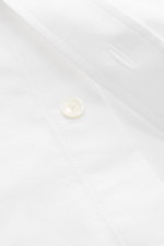 Close-up front view of Ami Paris Oxford Shirt Button-Down Collar White in pure cotton with button placket, sport cuff, logo stitching, and rounded hemline. Classic modern interpretation: The Oxford shirt by AMI PARIS in a classic design becomes the everyd