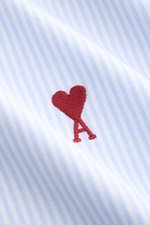 Ami Paris Casual Shirt Button-Down Collar Light Blue/White Striped, close-up front view showing fabric texture and red heart A logo embroidery, pure cotton, soft touch, oversized fit, classic stripe design, patch button placket, classic sport cuff, slight