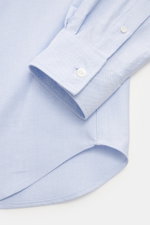 Maison Kitsuné Oxford shirt button-down collar light blue shown from a close-up angle focusing on the cuff and hem, featuring pure cotton Oxford fabric, soft feel, regular fit, button-down collar, signature logo stitching, classic barrel cuffs, inverted p