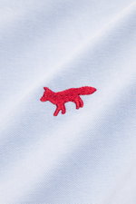 Close-up front view of Maison Kitsuné Oxford shirt button-down collar light blue highlighting pure cotton Oxford fabric, soft feel, signature red fox logo stitching. Features regular fit, button-down collar, classic barrel cuffs, inverted pleat on the bac