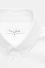 Close-up front view of Maison Kitsuné Oxford shirt button-down collar white, showing pure cotton Oxford fabric, soft feel, regular fit, button-down collar, signature logo stitching, classic barrel cuffs, inverted pleat on the back, and rounded hem.