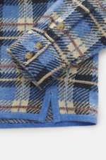Guest In Residence Cashmere knit shirt blue/navy/sand checkered shown in close-up from above, highlighting pure cashmere, soft touch, medium-fine knit pattern, regular fit, smooth button placket, turn-down collar, breast pockets with flap and button, and 