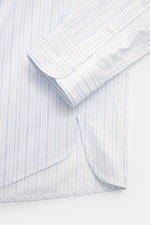 Jacquemus Casual shirt kent collar light blue/white striped shown from a close-up side angle, featuring pure cotton, soft smooth feel, fine stripe pattern with logo woven detail, oversized fit, Kent collar, concealed button placket, initial patch on the c